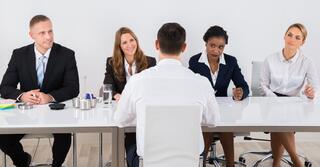 Panel interview setting with four interviewers and the candidate facing to the panel.