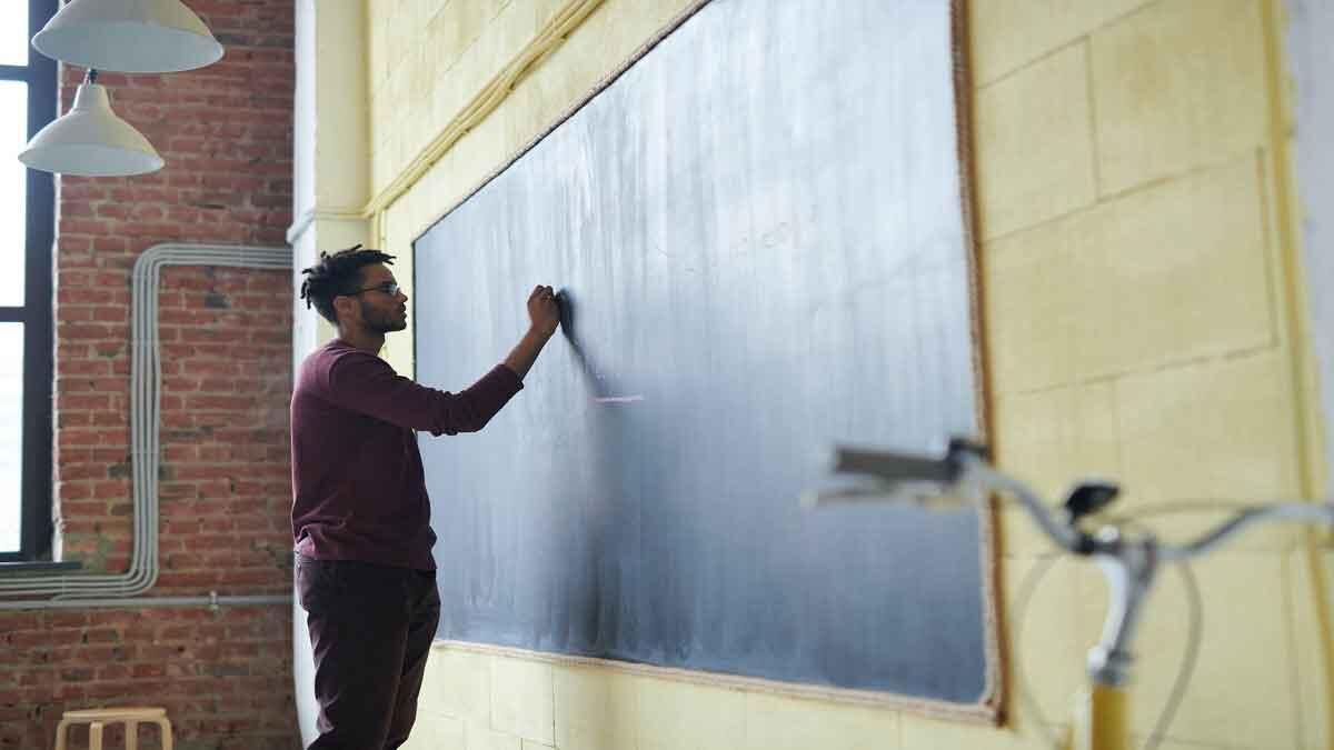 Teacher writing on blackboard