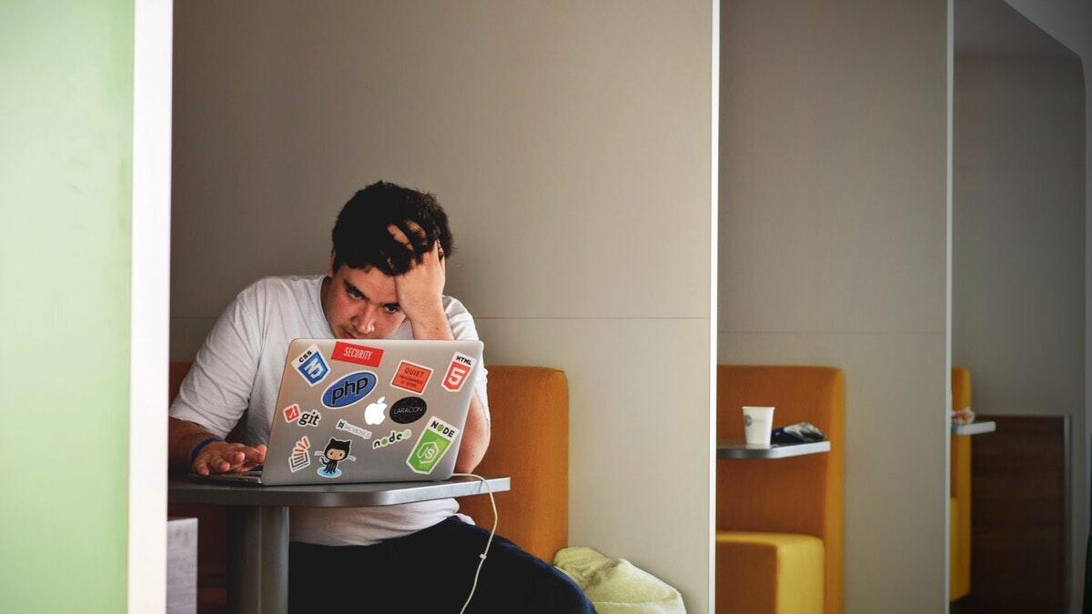 student at laptop looking stressed
