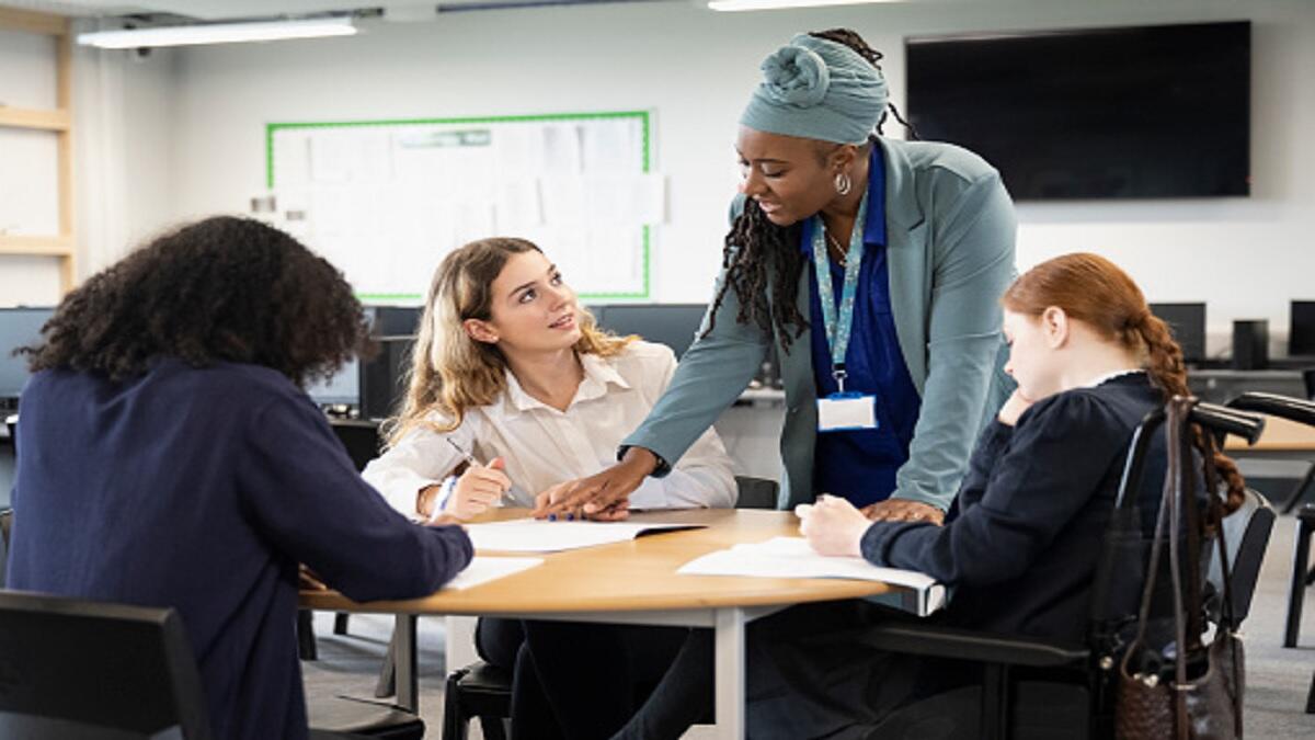 A teaching assistant helping a group of learners.