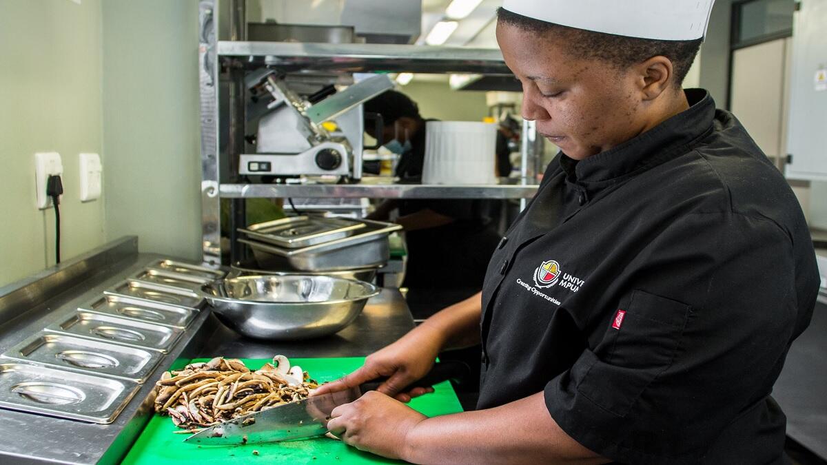 Hospitality students chops mushrooms at the university's hotel