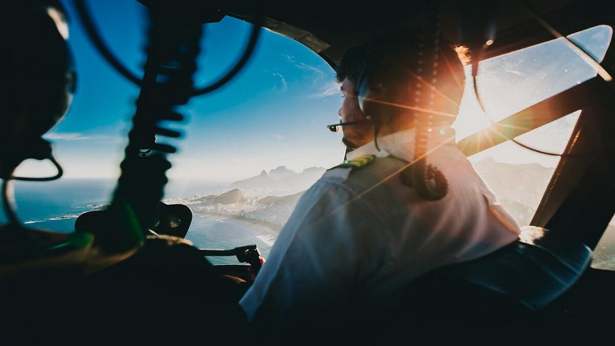 Seasoned pilot testing aviation student on flying a helicopter