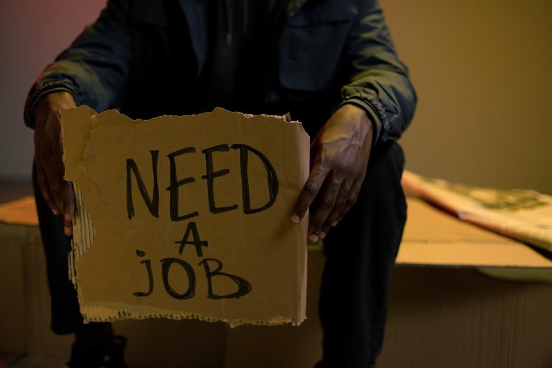 unemployed person holds cupboard as he searches for a job