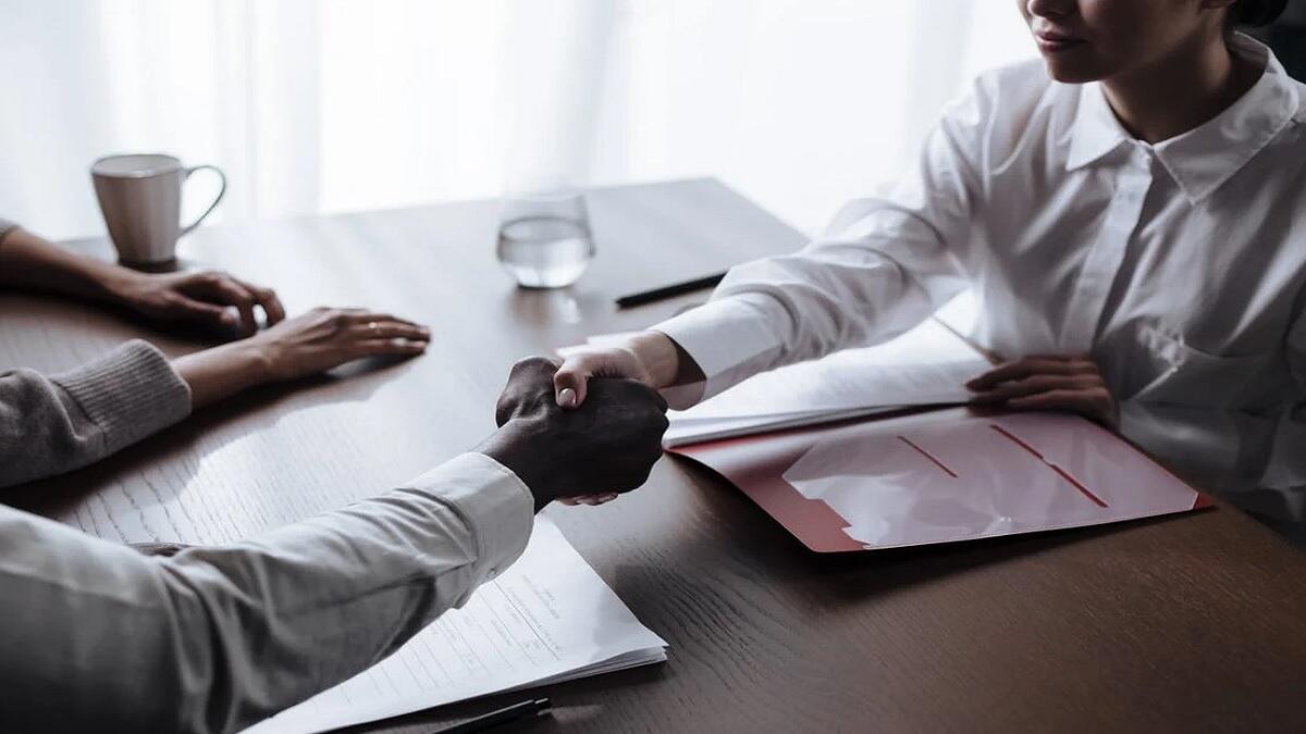Social work graduate shakes hands with new employer