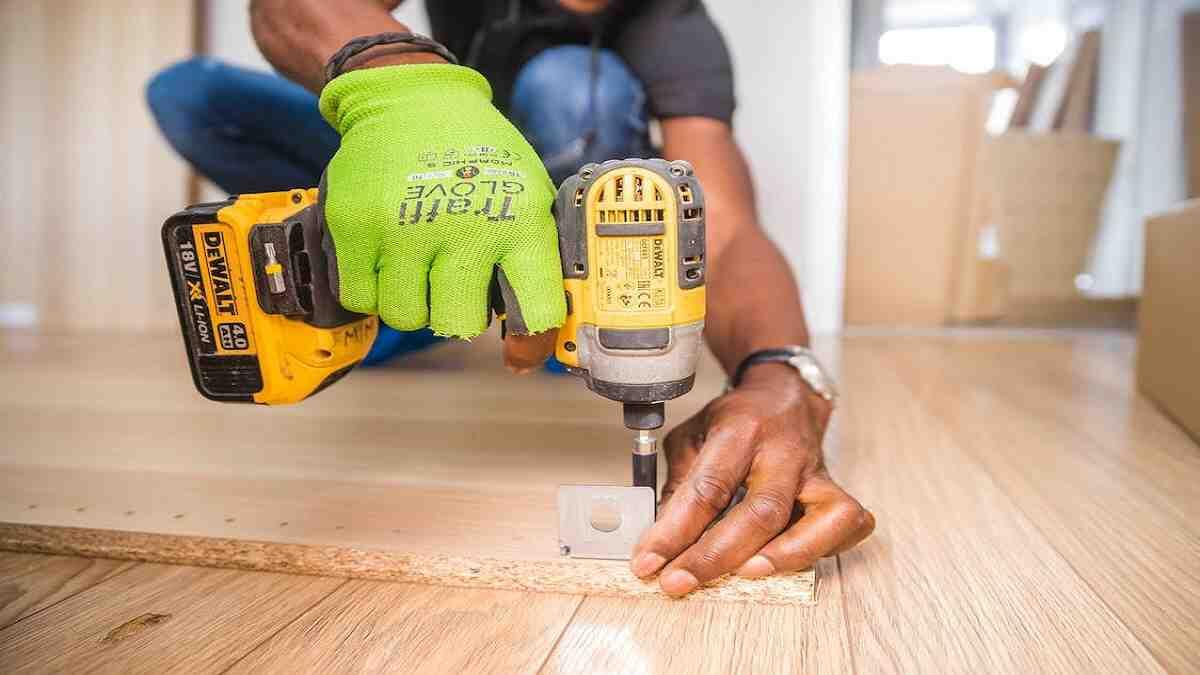 Carpenter drills brown board as part of trade test practicals