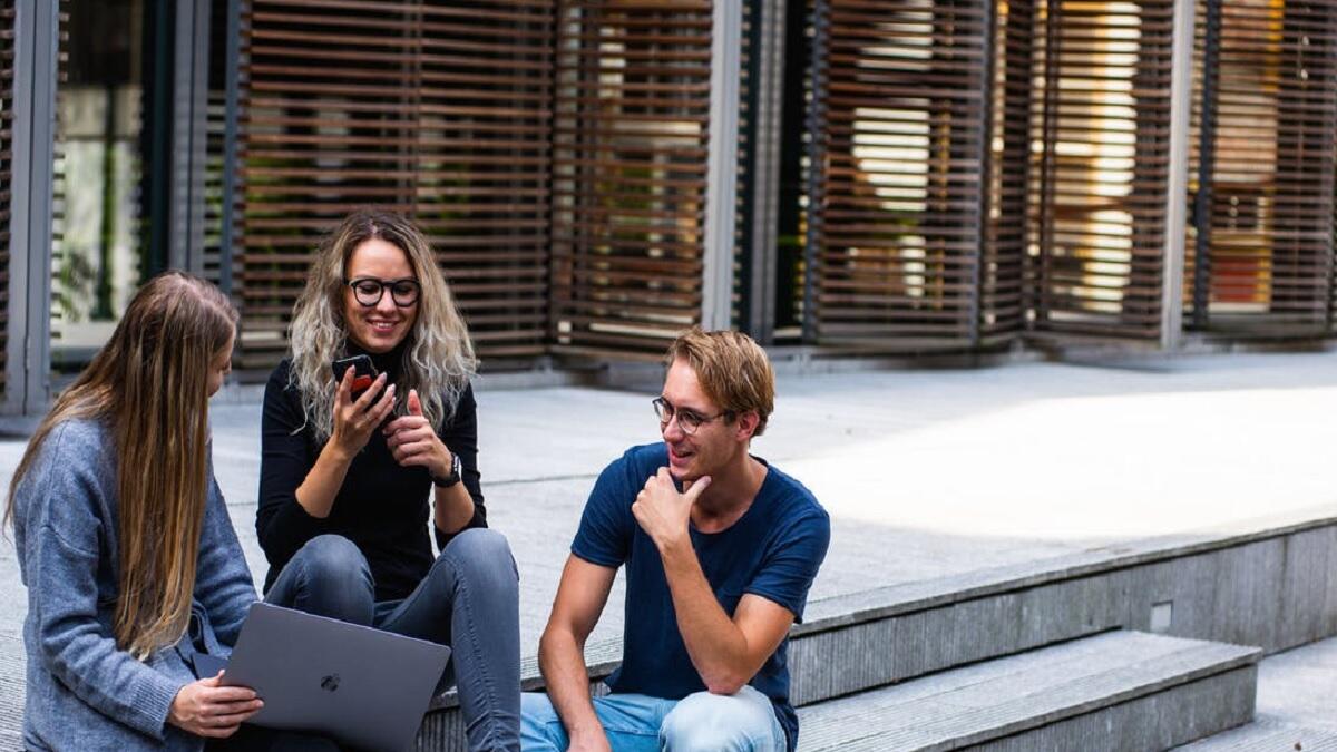 Students explore AI courses on university website using laptop