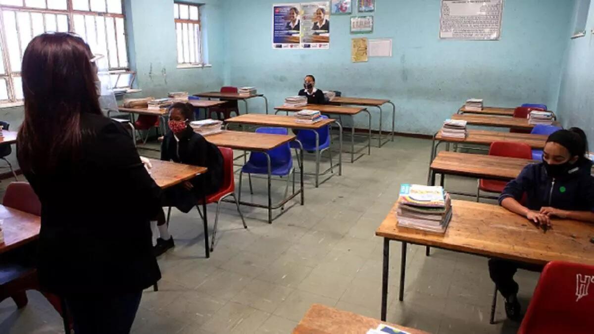 An assistant monitors learners in a classroom
