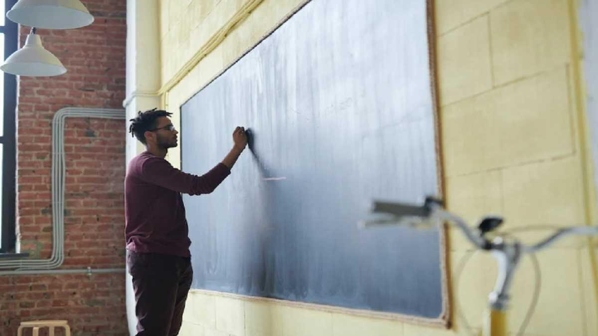 Teacher writing on a board in a classroom