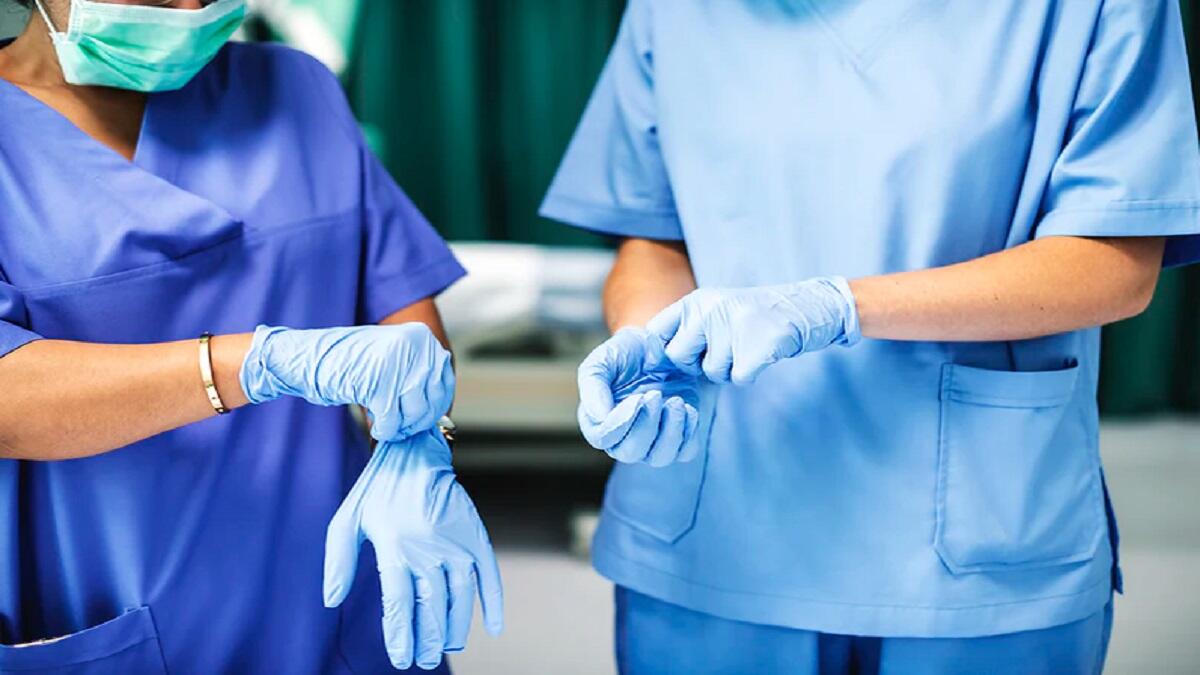 Two nurses in blue scrubs studying doing postgraduate nursing courses 