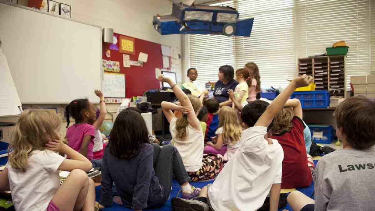 Teaching assistant reading to learners in a classroom