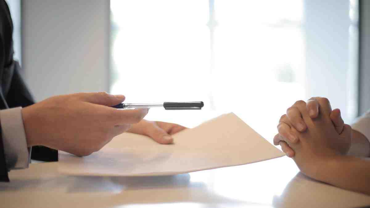 Bursar passing a student a bursary agreement