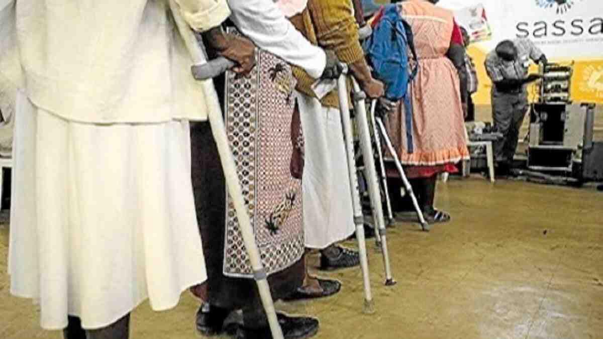 Sassa Old Person's Grant beneficiaries wait in line to receive their grant payouts