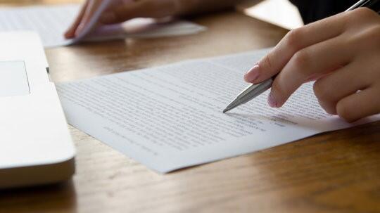 A student with a pencil in their hand whilst writing an essay