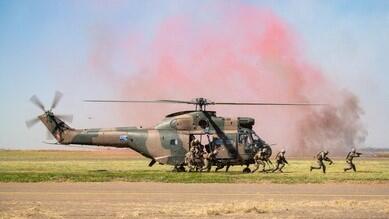 the SANDF in duty as they hop out of a helicopter