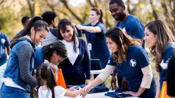 Young volunteers handing out shirts at a volunteer desk