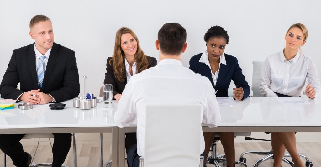Panel interview setting with four interviewers and the candidate facing to the panel.