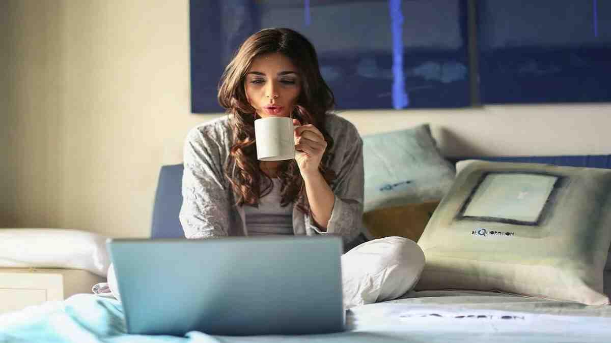 Student sitting on bed with laptop