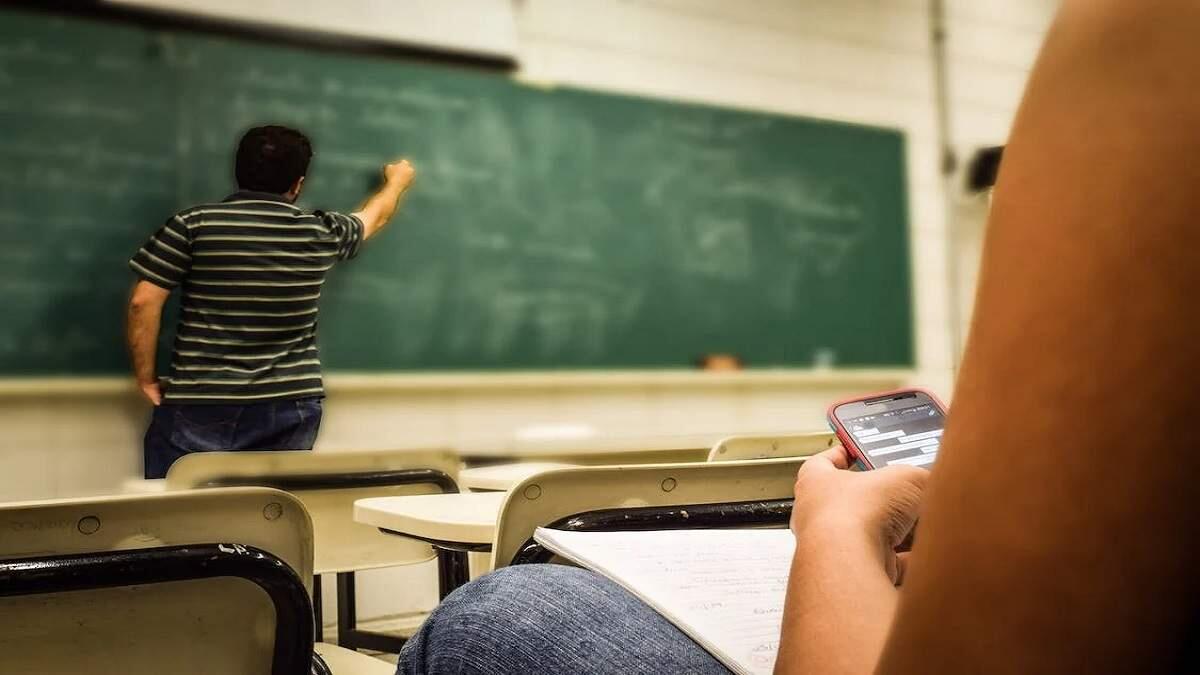 Man in classroom writing on board