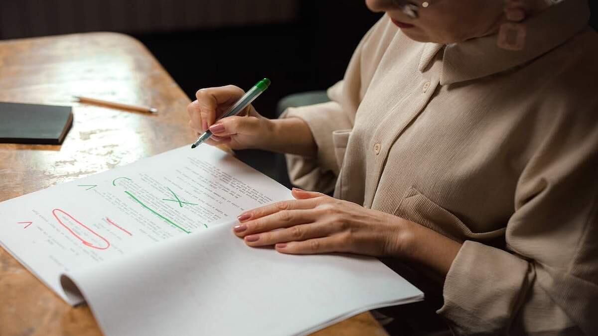 Person sitting with paperwork and pen