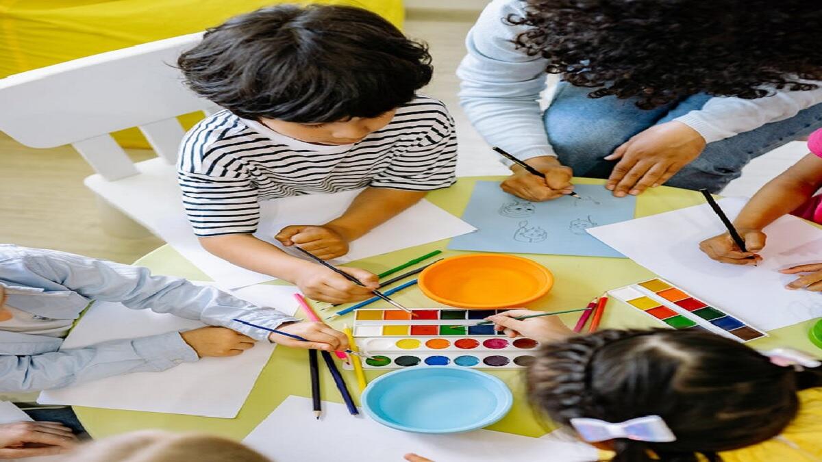 Teacher and children doing work around a desk