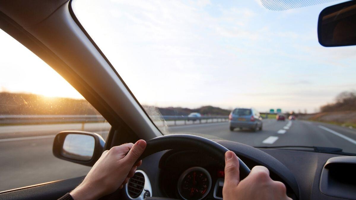 person driving with hands on steering wheel
