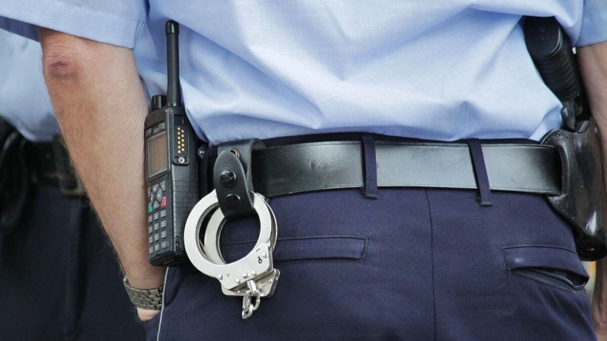 handcuffs hooked into a police offers belt