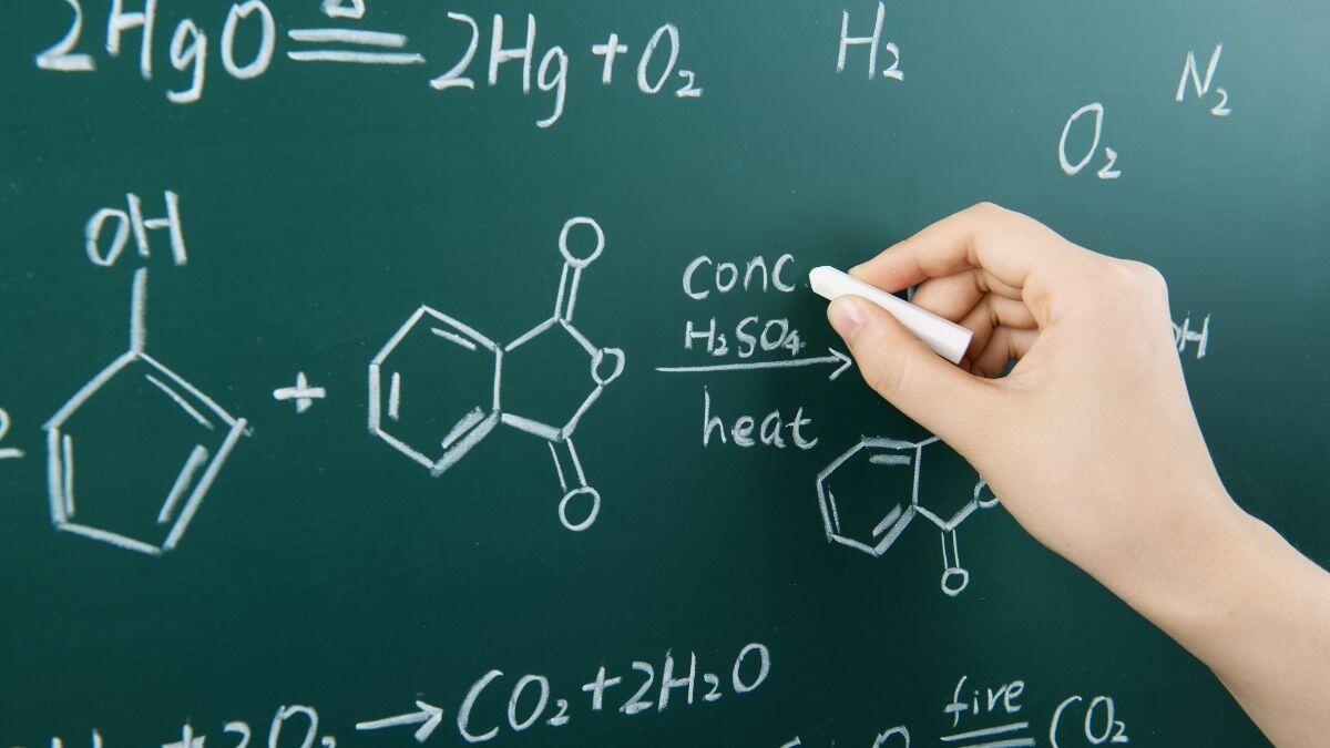 person writing on a blackboard