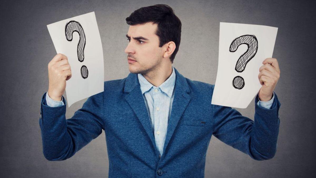 Man holding question marks