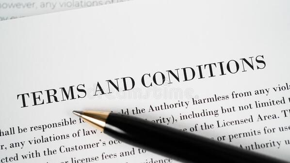 A zoomed in page of terms and conditions with a pen on top of it