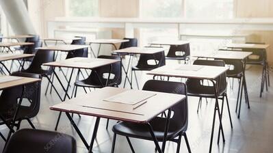 An exam room with rows of chairs and tables in it