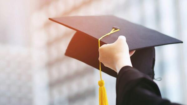 A black graduate cap hand lifted 