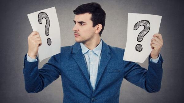 Man holding question marks